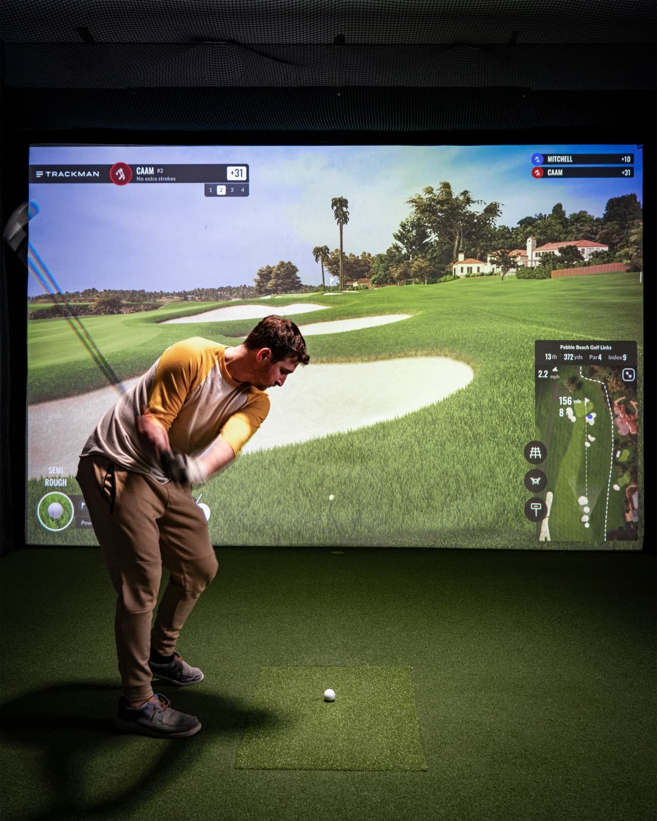 Golfer swinging in a Kemptville simulator bay